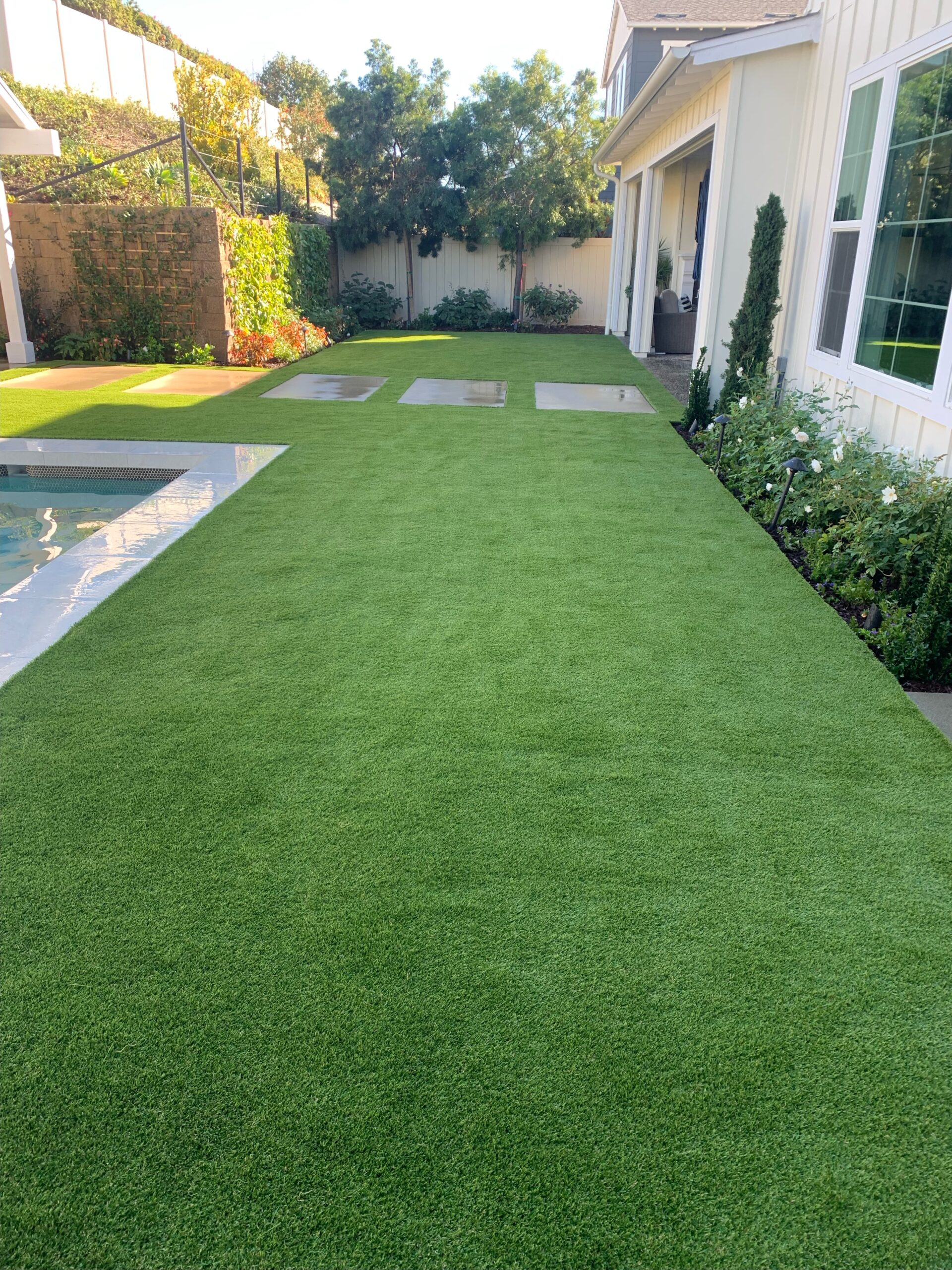 Turf with pavers beside a pool