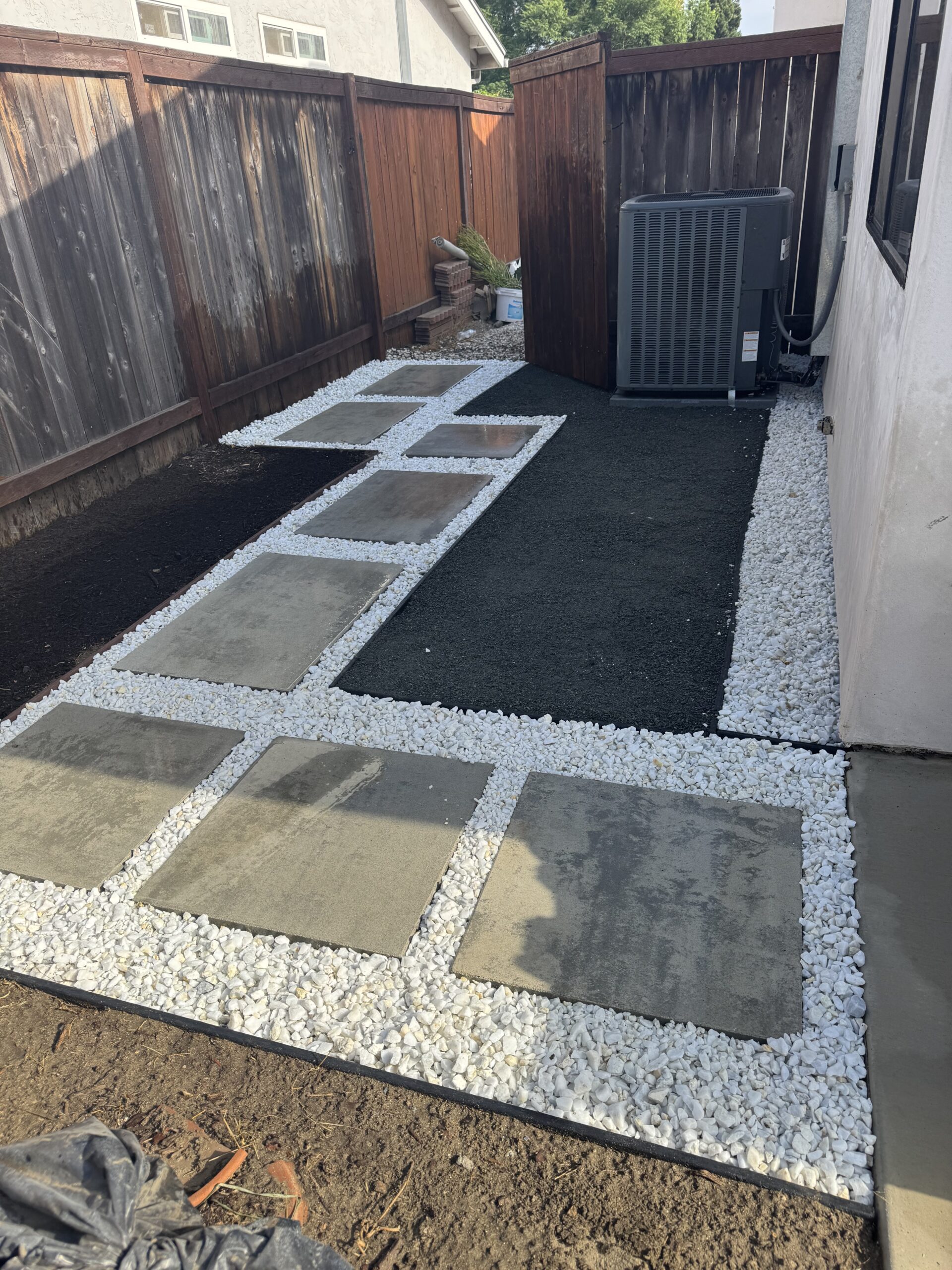 Modern geometric walkway with square concrete pavers set in white crushed gravel